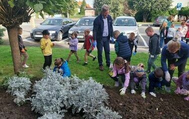 Dzieci z Zespołu Szkolno - Przedszkolnego w Przewornie z W&oacute;jtem Gminy sadzą cebulki żonkili.
