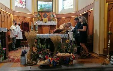 Ołtarz liturgiczny - ksiądz całujący chleb dożynkowy