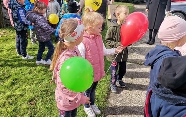 Na zdjęciu znajdują się dzieci z balonami 