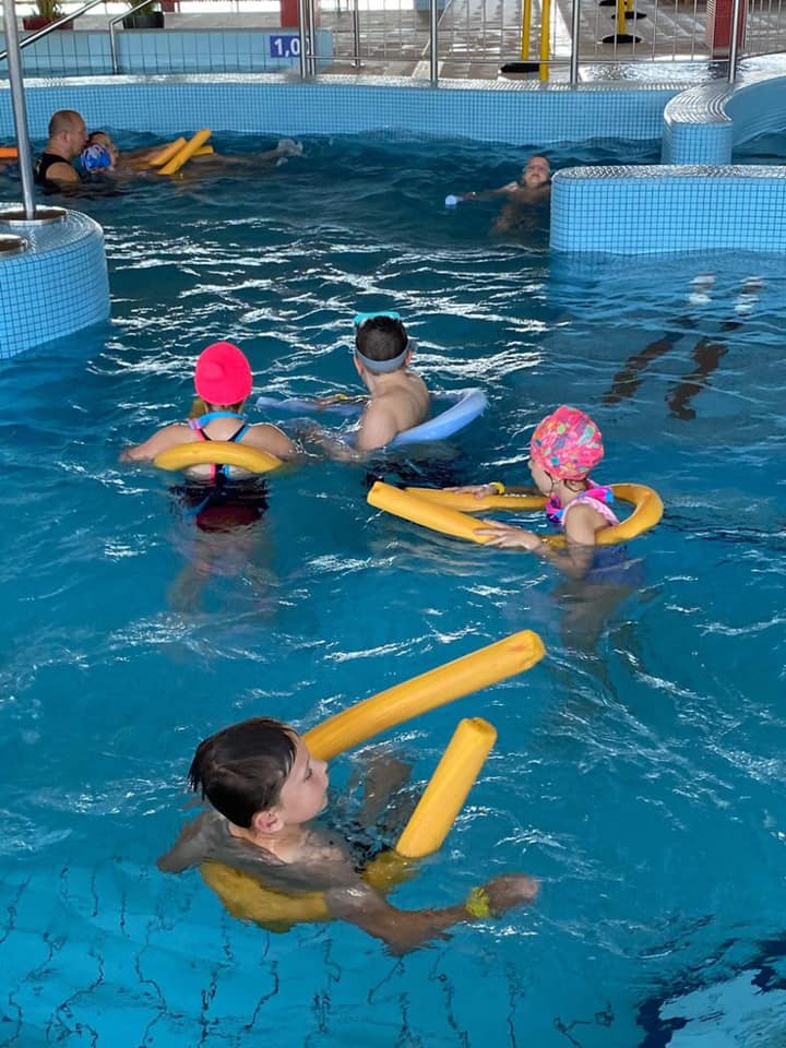 Dzieci na basenie z instruktorem